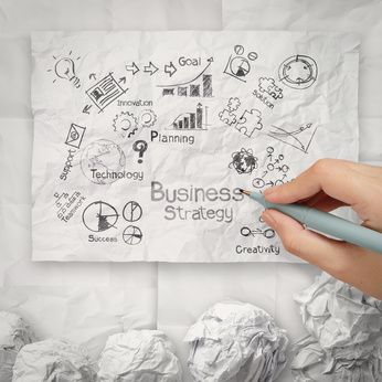 hand drawing creative business strategy on crumpled paper backgr
